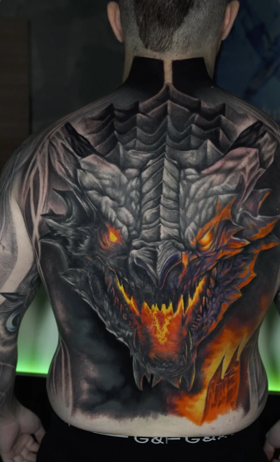 Tatuaje de dragón a color, espalda completa con efectos de fuego