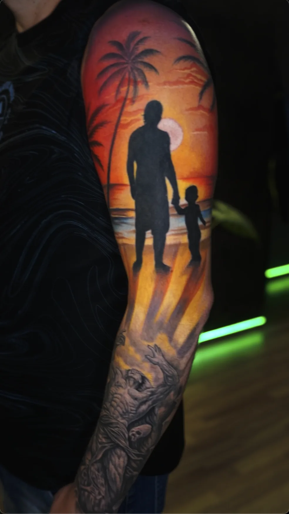 Tatuaje a color de manga completa, silueta padre e hijo en atardecer con palmeras