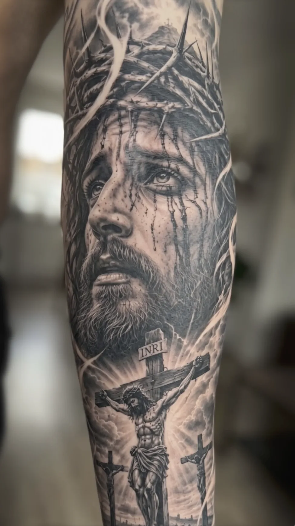 Tatuaje black and grey de Cristo con corona de espinas, manga completa