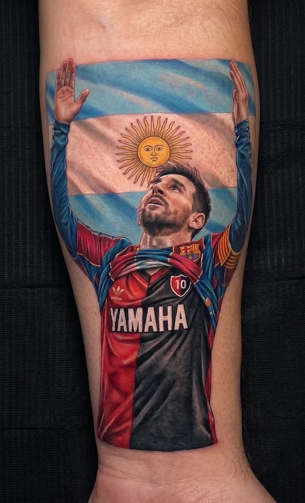 Tatuaje retrato realista a color de Lionel Messi con bandera Argentina
